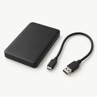External hard drive in black, viewed from above with an unplugged USB cable beside it