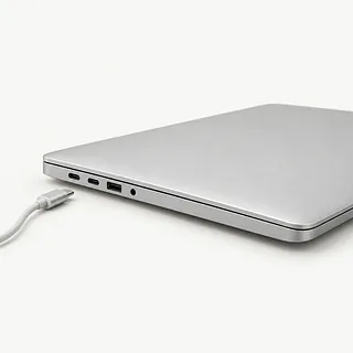Laptop in silver, closed left-side view with USB-C ports and an unplugged charging cable