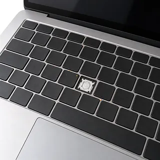 MacBook in silver, keyboard close-up with a missing keycap exposing a white mechanism and crumbs between black keys