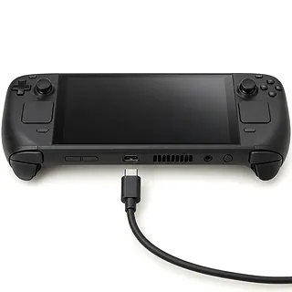 Steam Deck OLED in black, front view with lint in the USB-C port and an unplugged USB-C cable below