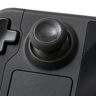 Steam Deck OLED in black, front close-up with a worn left analog stick and grime around its base