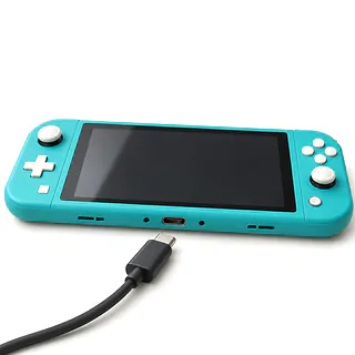 Nintendo Switch Lite in turquoise, bottom edge with lint in the USB-C port and an unplugged cable nearby